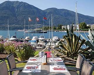 Tavolo all&#039;aperto con vista sul lago e montagne.