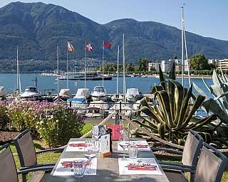 Tavolo all&#039;aperto con vista sul lago e montagne.